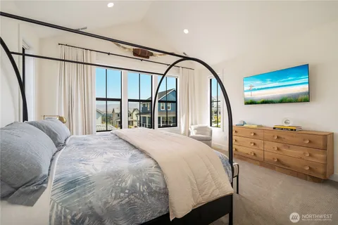 a bedroom with a bed window and a flat screen tv