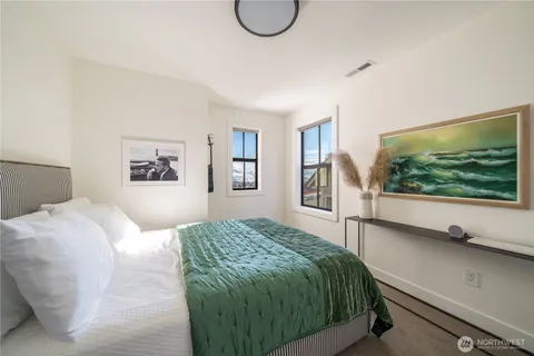 a bedroom with a large bed and a flat tv screen on dresser