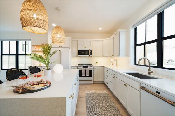 a kitchen with stainless steel appliances granite countertop a sink a stove and a refrigerator