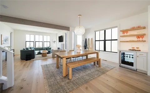 a living room with furniture a window and a dining table with wooden floor