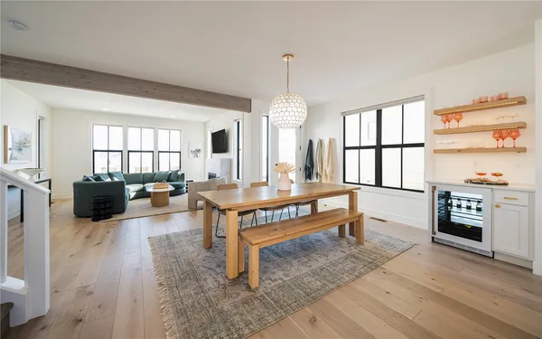 a living room with furniture a window and a dining table with wooden floor