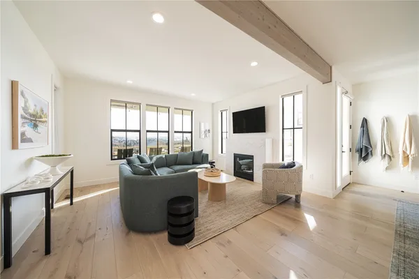 a living room with furniture a large window and a wooden floor
