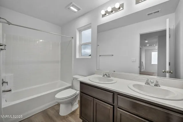 a bathroom with a granite countertop sink toilet a large mirror a bathtub and shower