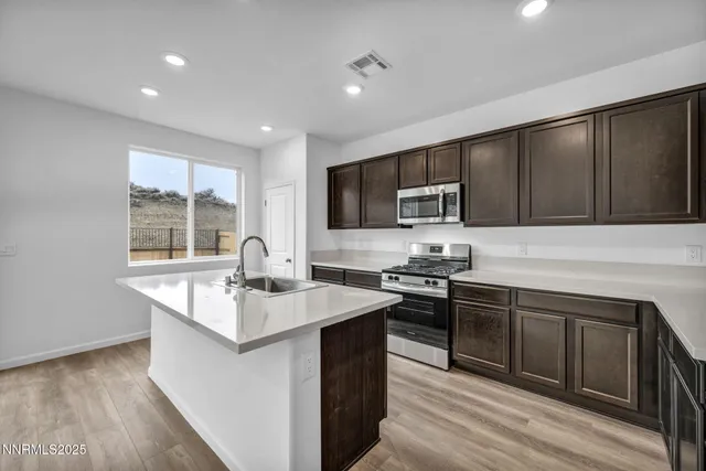 a kitchen with stainless steel appliances granite countertop a sink stove microwave and refrigerator