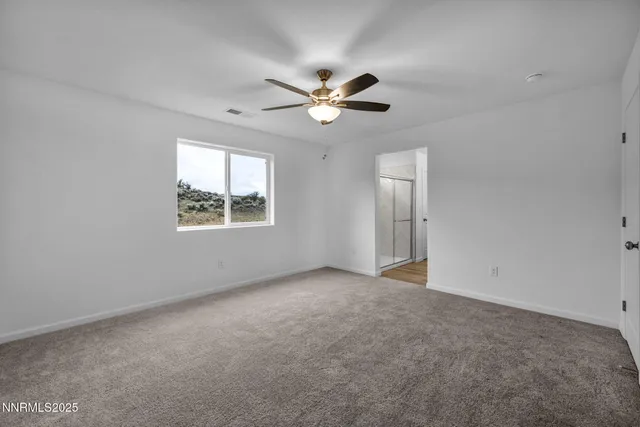 an empty room with a window and a fan