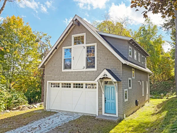 a view of a house with wooden fence next to a yard