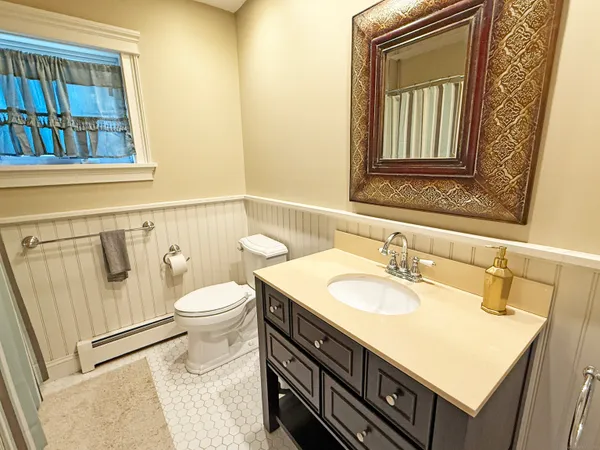 a bathroom with a sink a toilet and a mirror