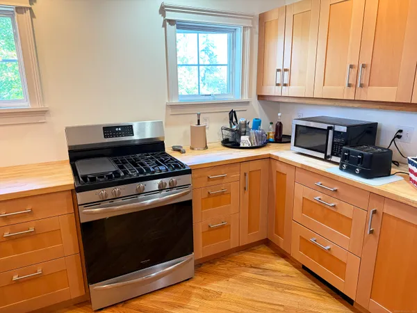 a kitchen with wooden floor and refrigerator