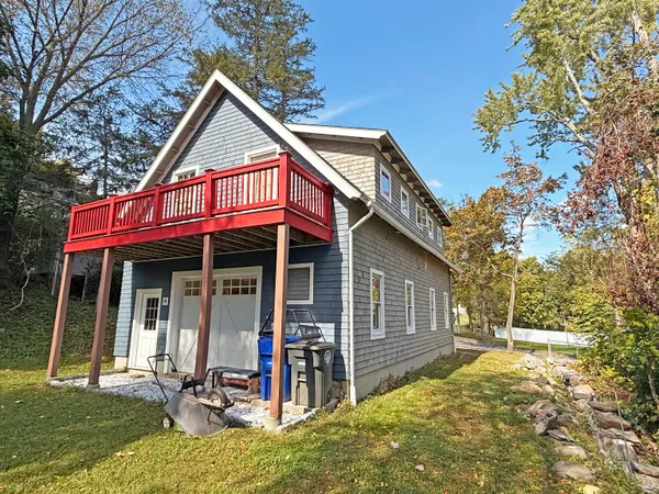 a view of a house with a small yard and wooden fence