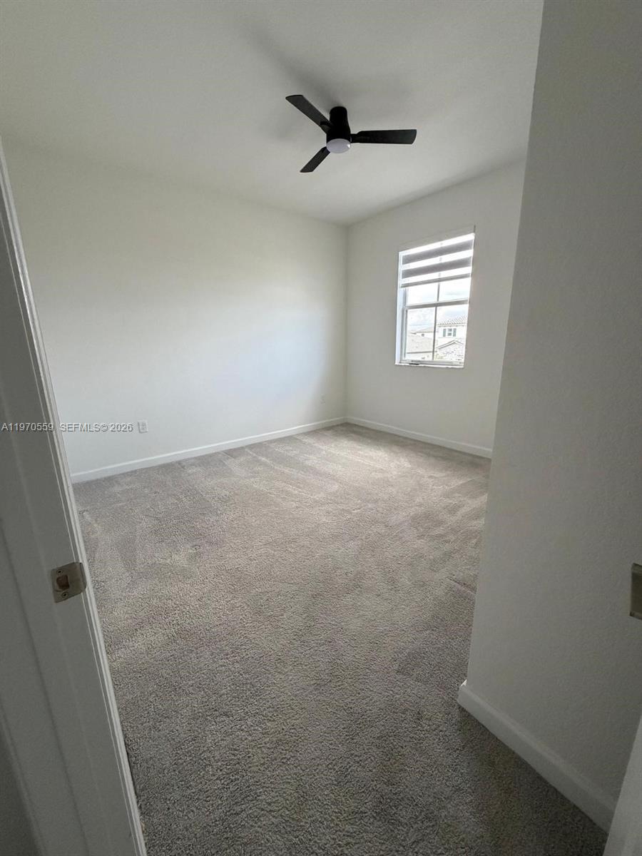 2638 Southeast 9th Street Homestead, FL 33035 - Photo 26 of 36 an empty room with windows and ceiling fan