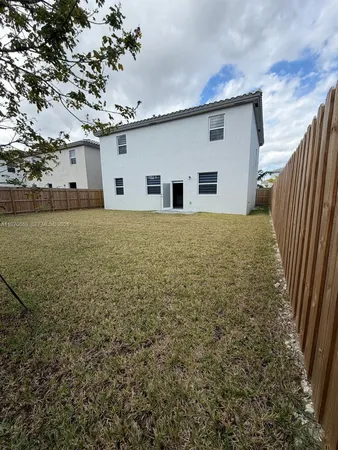 a view of backyard of house and trees