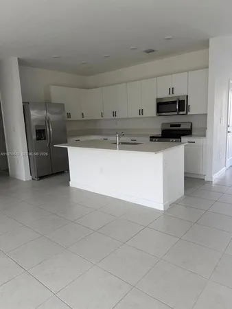 a kitchen with stainless steel appliances granite countertop a sink a stove and a refrigerator