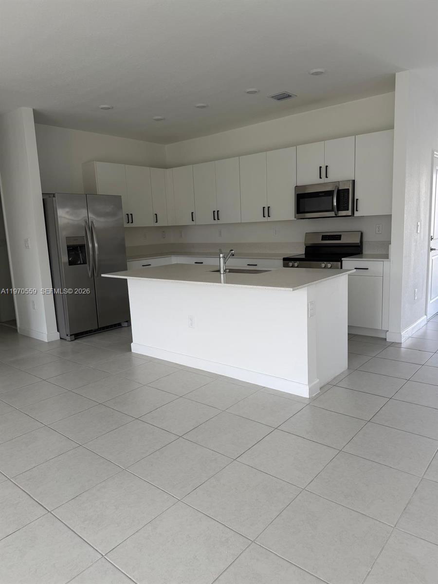 2638 Southeast 9th Street Homestead, FL 33035 - Photo 9 of 36 a kitchen with stainless steel appliances granite countertop a sink a stove and a refrigerator