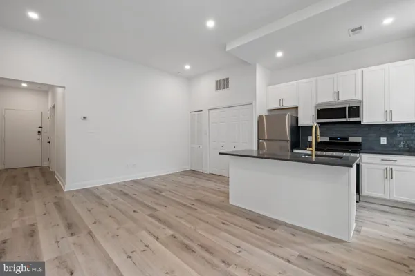 a kitchen with a stove top oven and refrigerator