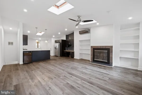 a kitchen with stainless steel appliances kitchen island granite countertop a refrigerator and a stove top oven