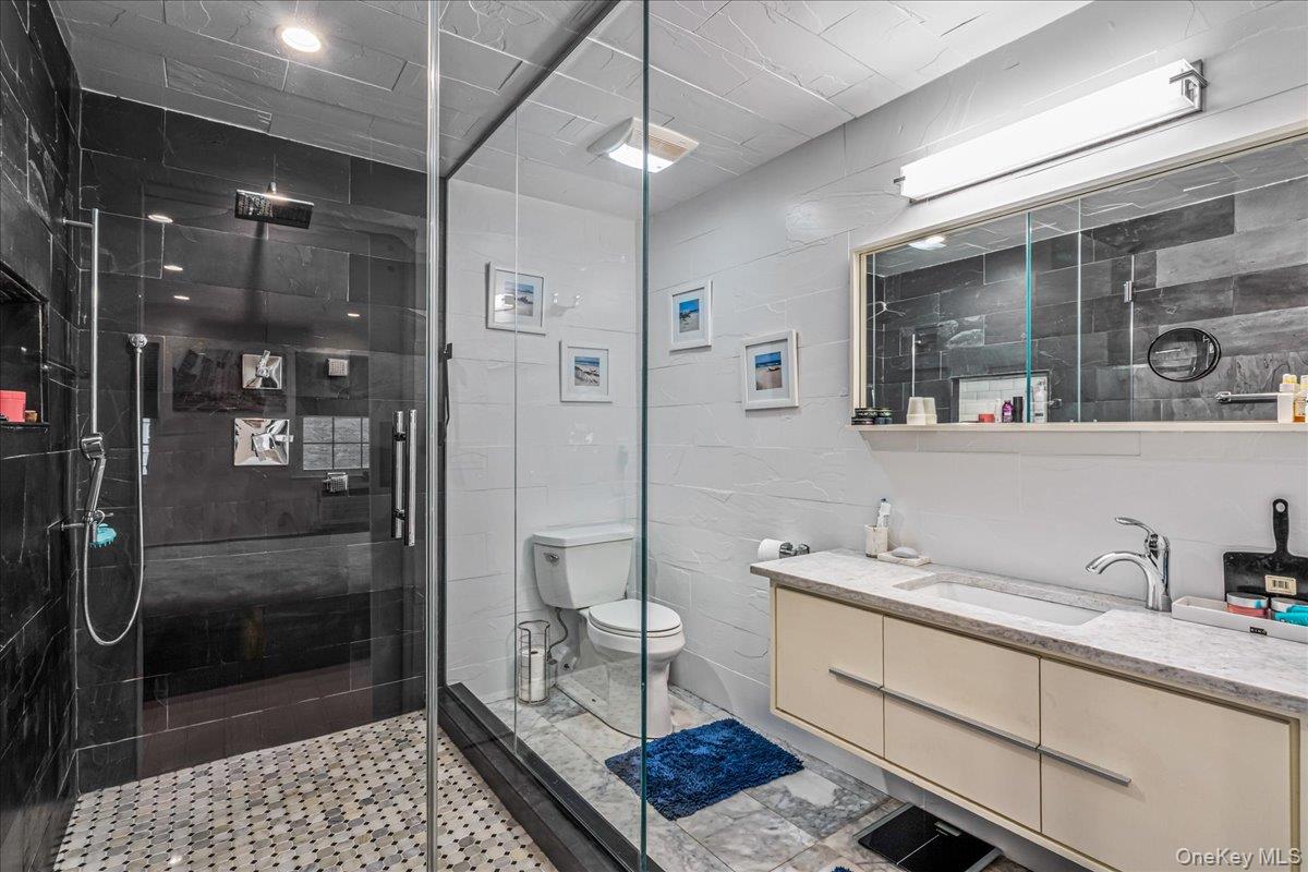 208-06 Robert Road, Unit 2 Queens, NY 11360 - Photo 6 of 26 a bathroom with a sink a toilet and shower
