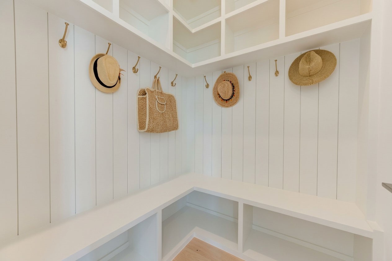 2311 Hollister Road Houston, TX 77080 - Photo 19 of 46 Charming drop zone adds both style and function with a built-in bench, wall paneling, overhead storage, and decorative hooks—an ideal landing spot for bags, jackets, and everyday essentials when coming and going.