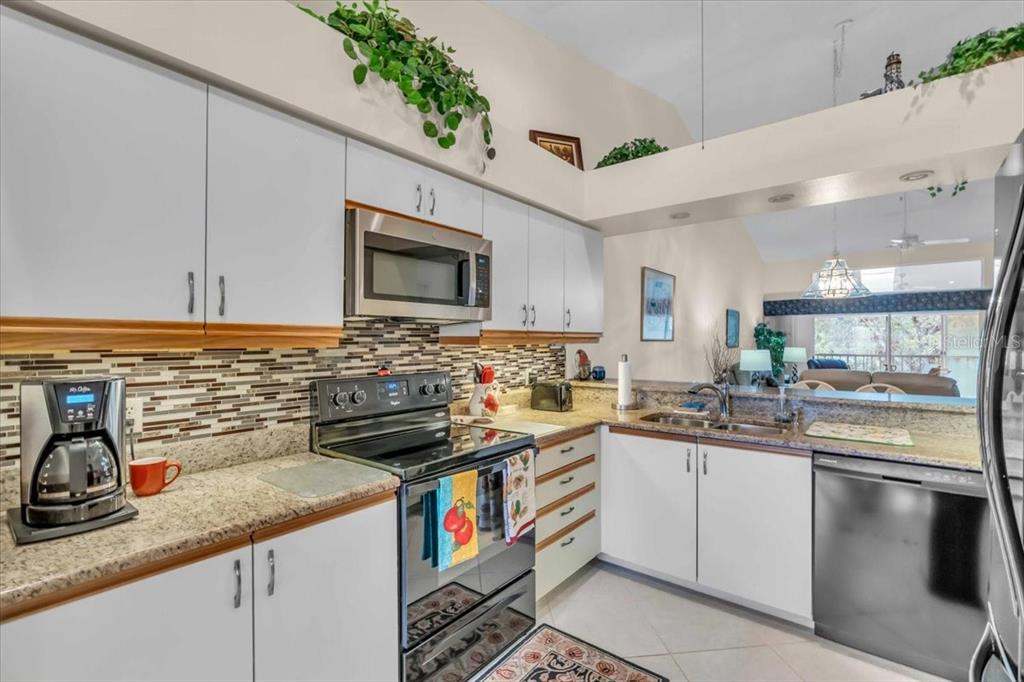 6713 Stone River Road, Unit 206 Bradenton, FL 34203 - Photo 16 of 58 a kitchen with stainless steel appliances granite countertop a sink stove and cabinets