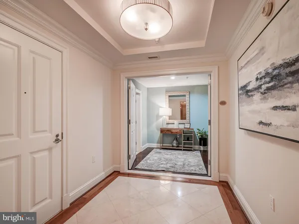 a view of a hallway with wooden floor and a living room