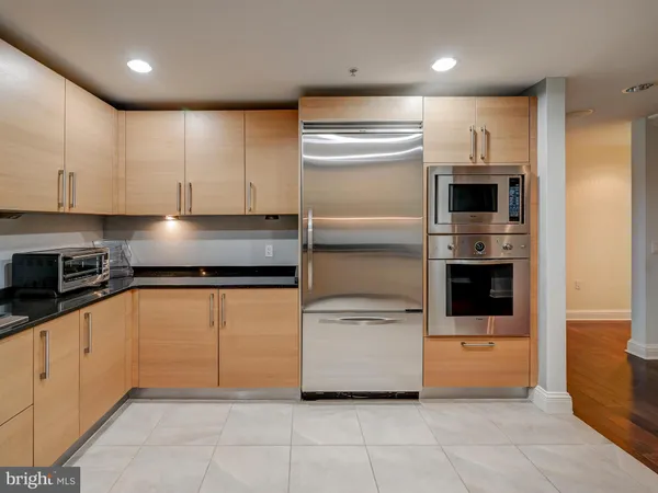 a kitchen with granite countertop a refrigerator and a stove top oven