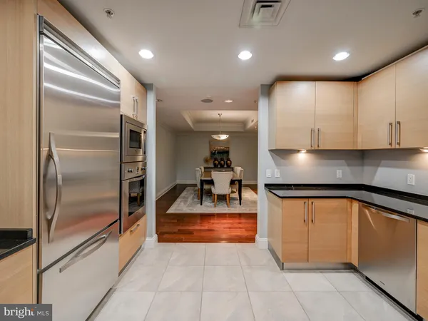 a kitchen with stainless steel appliances granite countertop a refrigerator and a sink