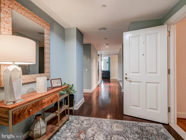 a view of a hallway with wooden floor and bathroom