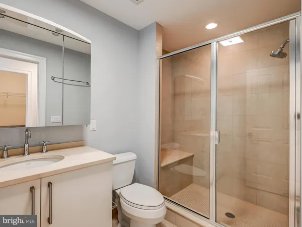 a bathroom with a shower sink vanity mirror and toilet