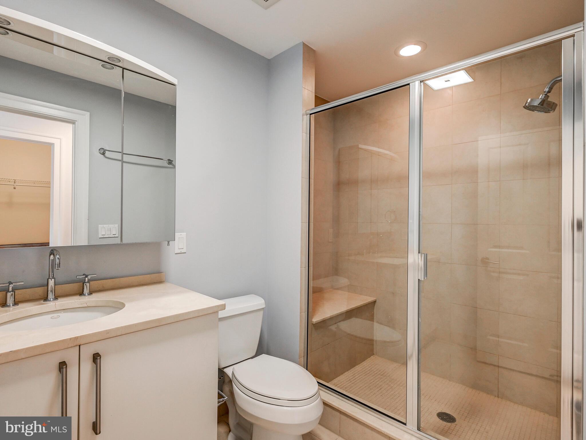 801 Key Highway, Unit 312 Baltimore, MD 21230 - Photo 32 of 45 a bathroom with a shower sink vanity mirror and toilet