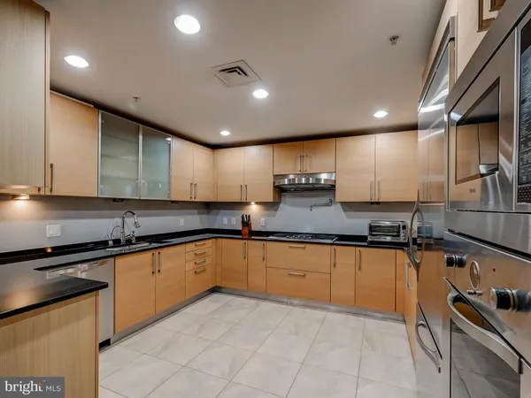 a large kitchen with granite countertop lots of counter space and sink