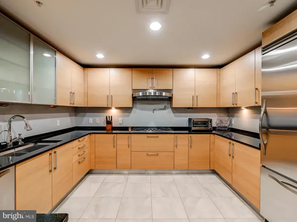 a large kitchen with stainless steel appliances granite countertop a sink stove and cabinets