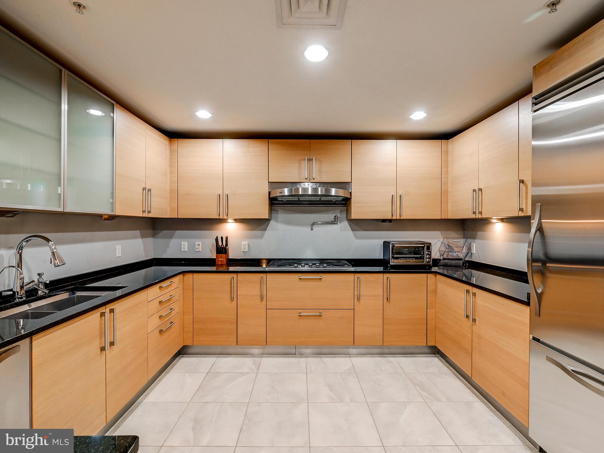 801 Key Highway, Unit 312 Baltimore, MD 21230 - Photo 9 of 45 a large kitchen with stainless steel appliances granite countertop a sink stove and cabinets