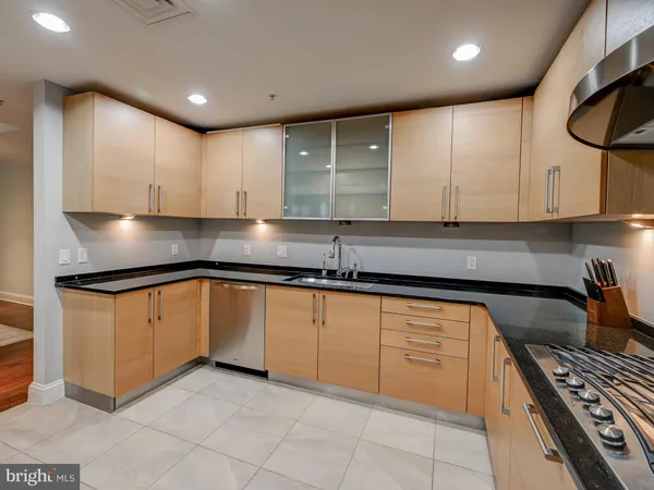 a kitchen with granite countertop a sink stove and cabinets