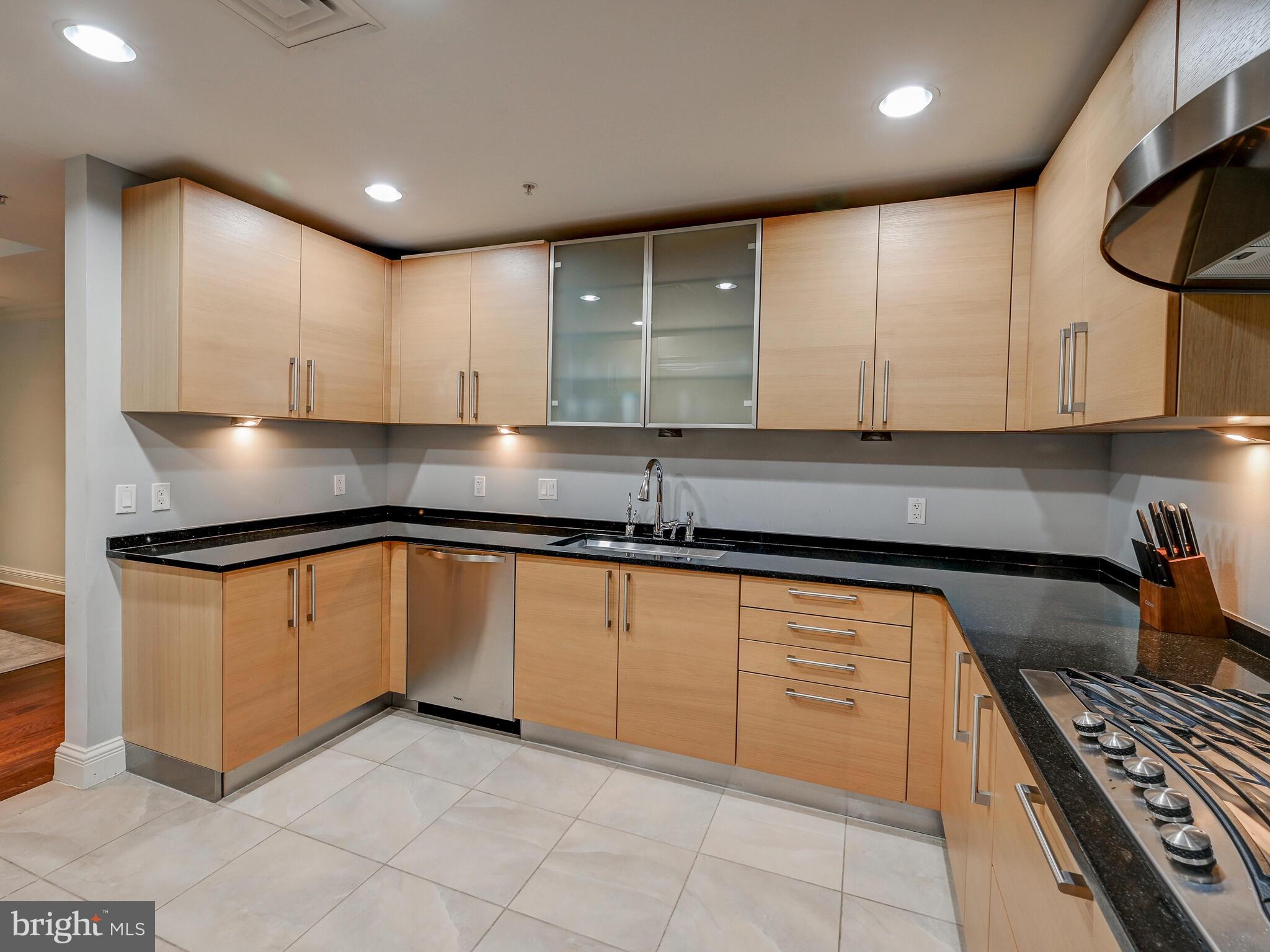 801 Key Highway, Unit 312 Baltimore, MD 21230 - Photo 10 of 45 a kitchen with granite countertop a sink stove and cabinets