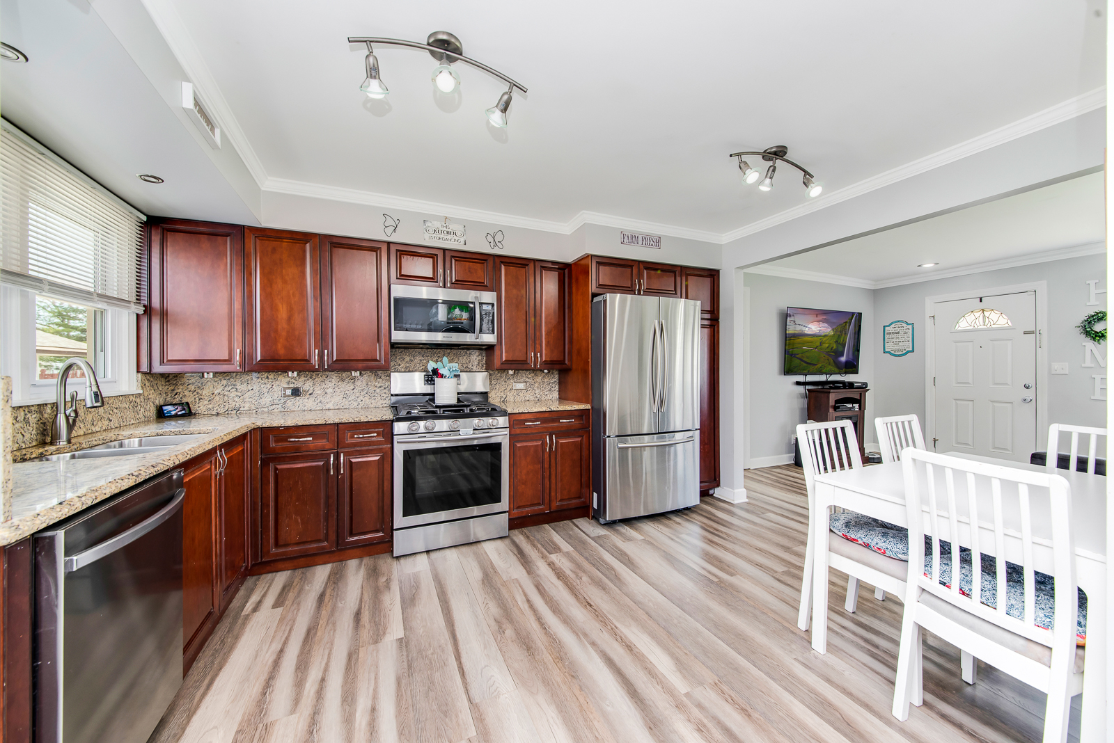 7517 Beloit Avenue Bridgeview, IL 60455 - Photo 5 of 18 a kitchen with stainless steel appliances granite countertop a refrigerator a stove top oven a sink dishwasher and wooden cabinets with wooden floor