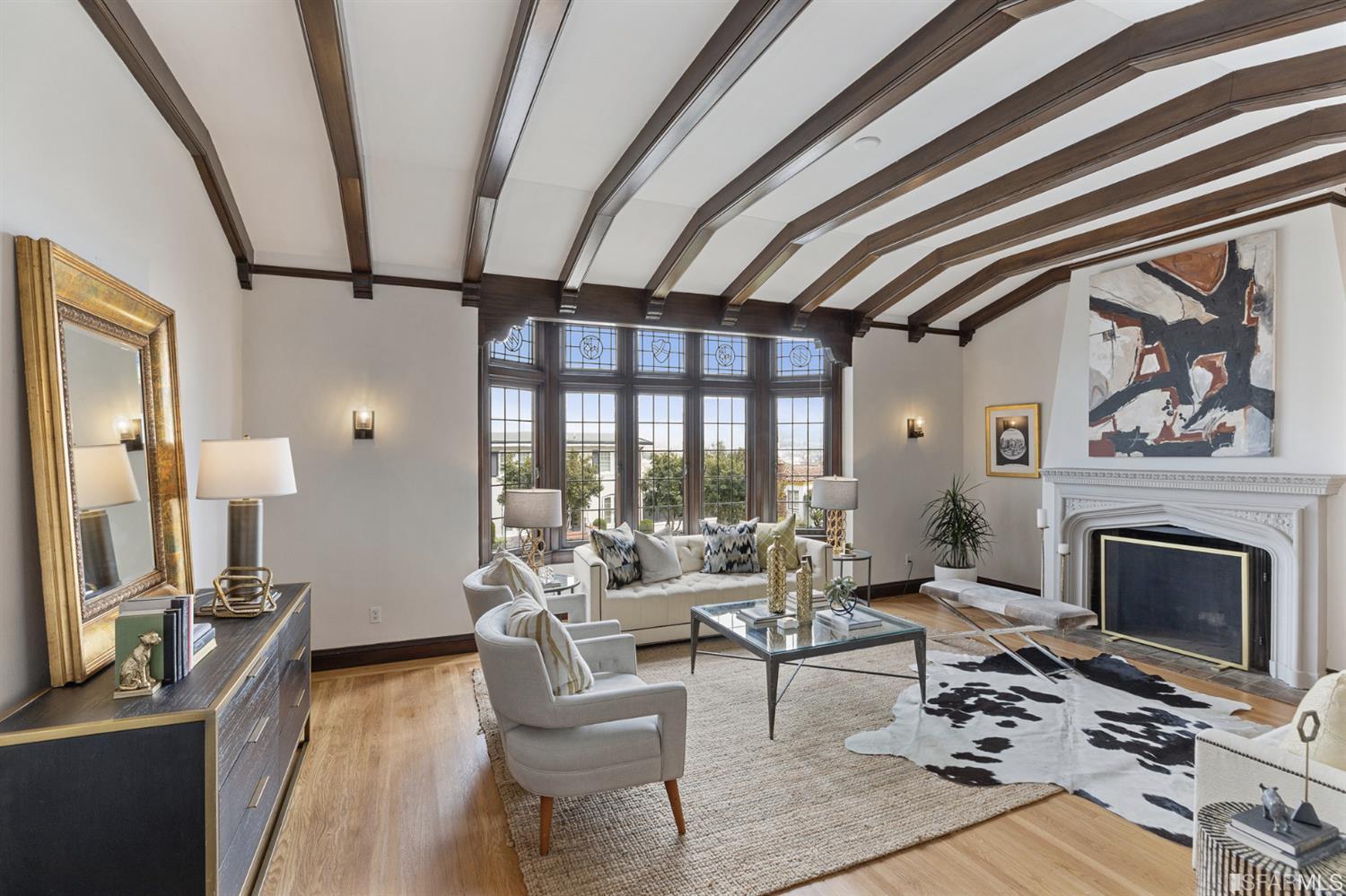 Classic and elegant San Francisco architecture with a formal step-down living room with vaulted ceilings and exposed beams. Enjoy an oversized wood-burning fireplace in the living room.