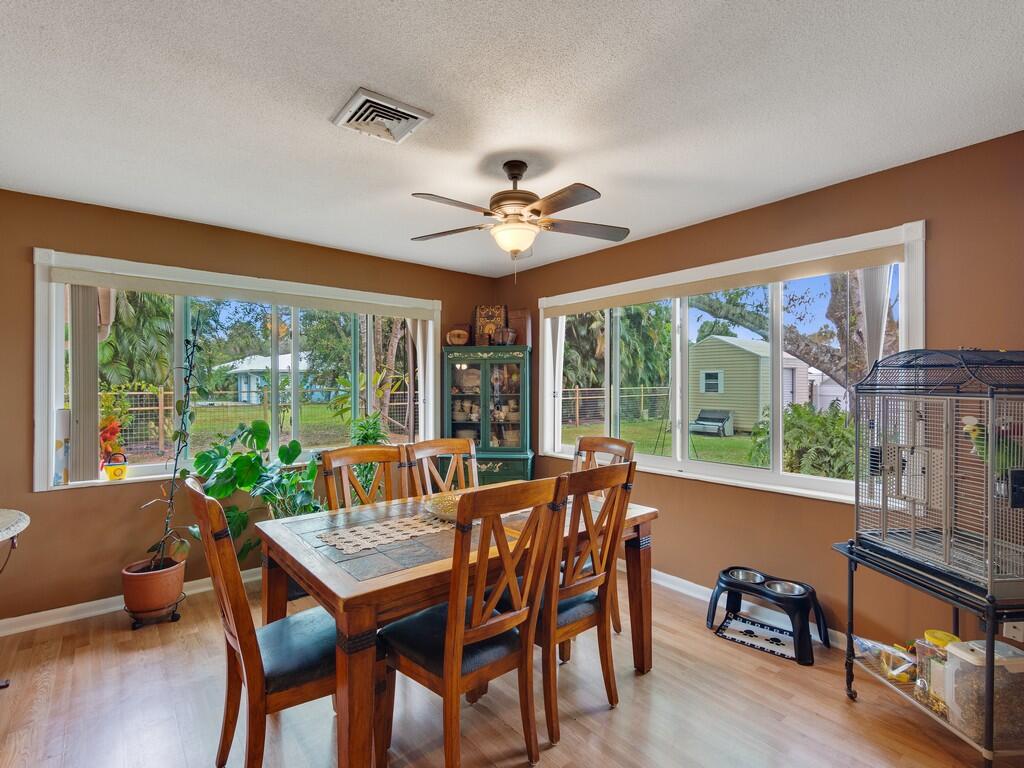 3118 Old Edwards Road Fort Pierce, FL 34981 - Photo 16 of 35 a dining room with furniture a chandelier and wooden floor