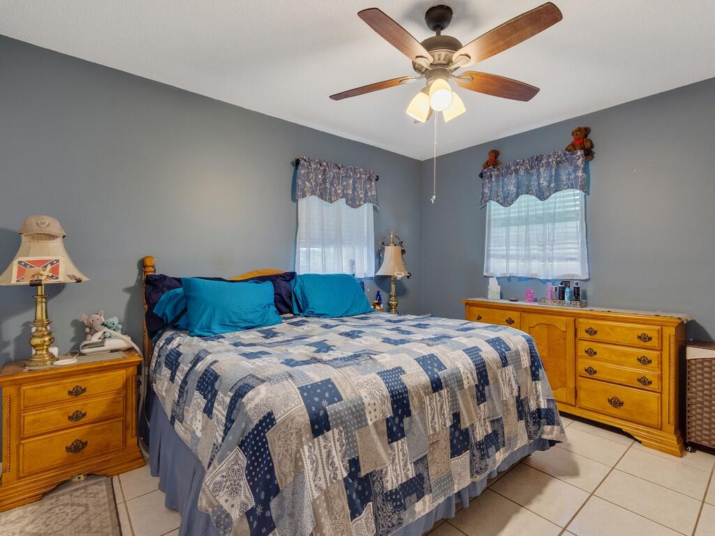 3118 Old Edwards Road Fort Pierce, FL 34981 - Photo 17 of 35 a bedroom with a bed and a chandelier