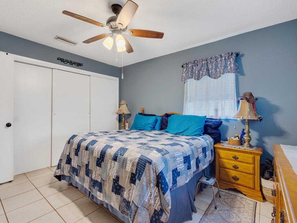 3118 Old Edwards Road Fort Pierce, FL 34981 - Photo 18 of 35 a bedroom with a bed and a chandelier