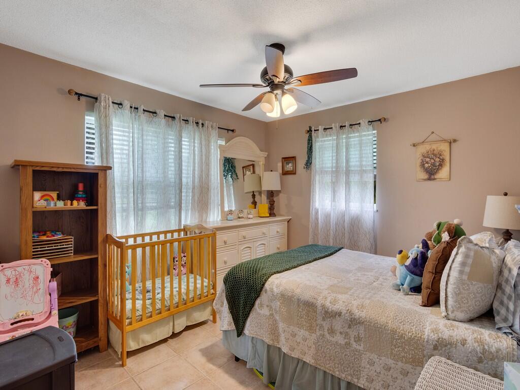 3118 Old Edwards Road Fort Pierce, FL 34981 - Photo 19 of 35 a bedroom with a bed and a chandelier