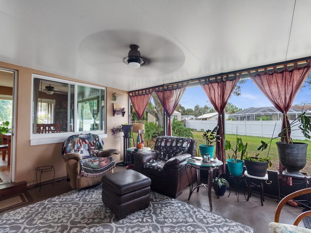3118 Old Edwards Road Fort Pierce, FL 34981 - Photo 22 of 35 a living room with furniture ceiling fan and a floor to ceiling window