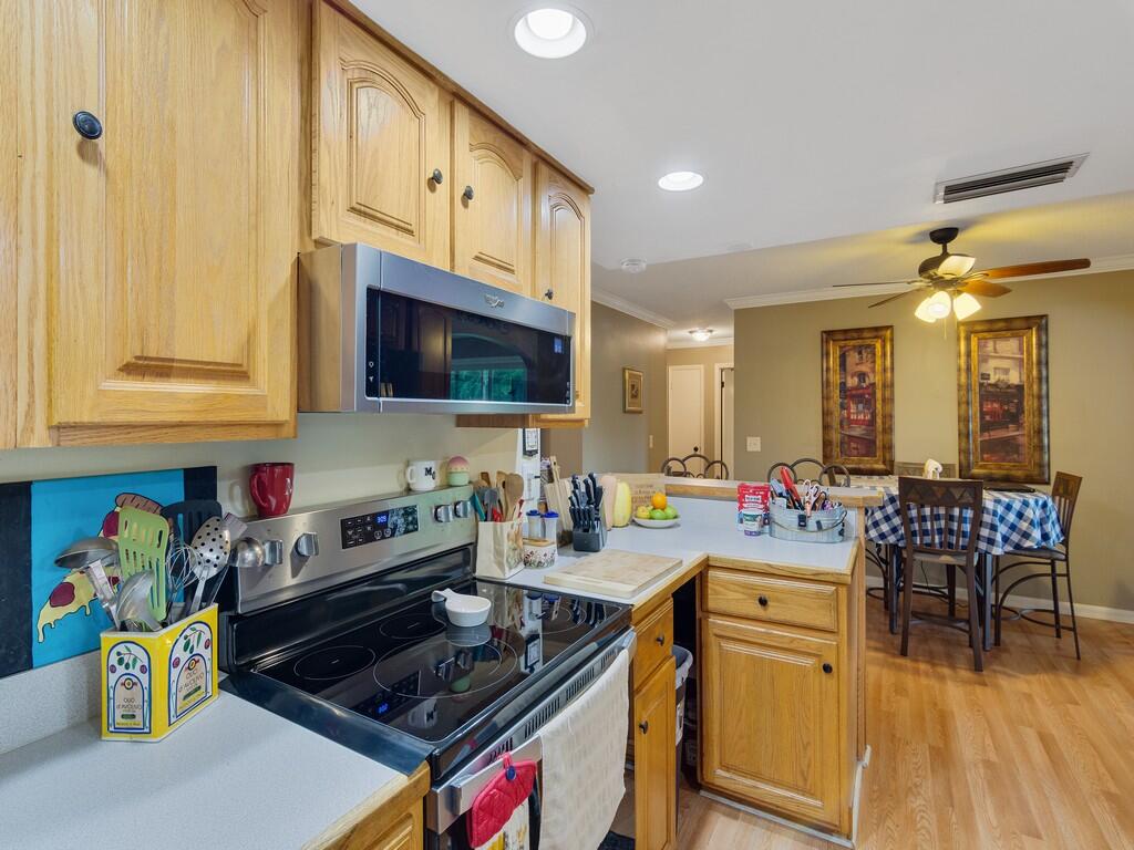 3118 Old Edwards Road Fort Pierce, FL 34981 - Photo 5 of 35 a kitchen with stainless steel appliances a stove a sink cabinets and a dining table