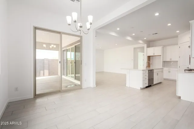 a view of a kitchen with refrigerator and white cabinets
