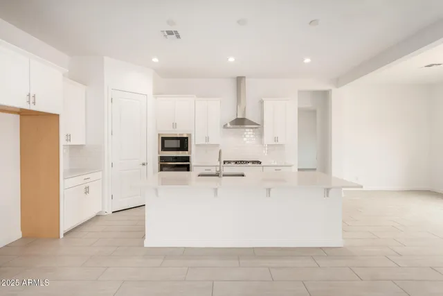 a large white kitchen with cabinets and stainless steel appliances