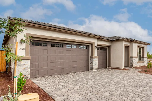 a backyard of a house with potted plants and large tree
