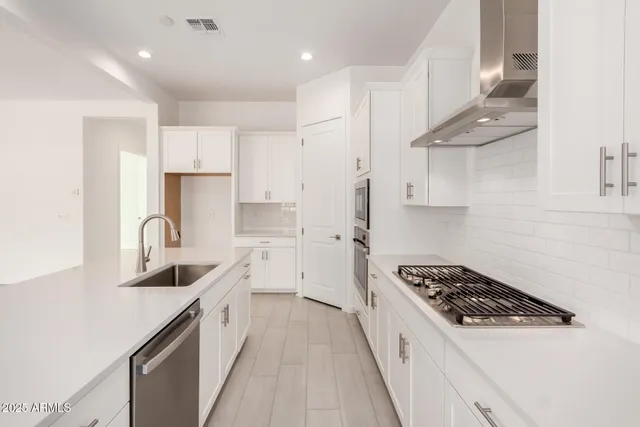a kitchen with stainless steel appliances a sink stove and refrigerator