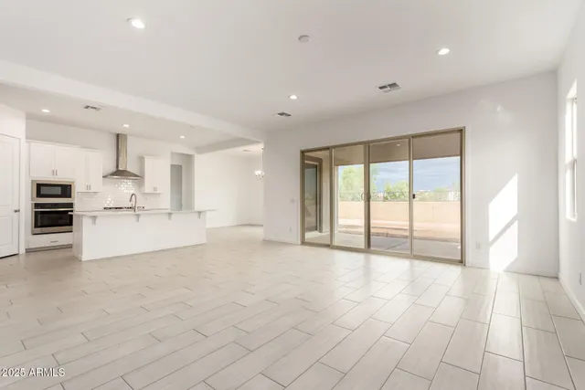 a view of kitchen with stainless steel appliances refrigerator oven and cabinets