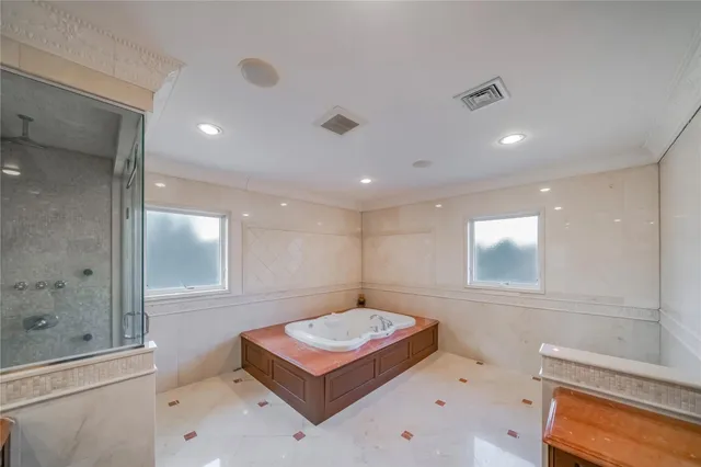a bathroom with a tub shower sink and mirror