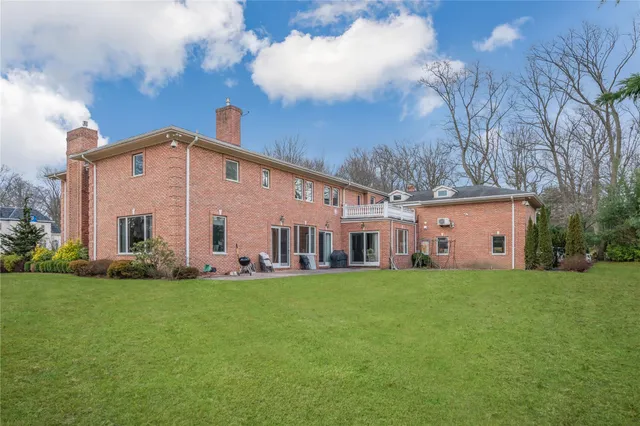 a big white house with a big yard and large trees