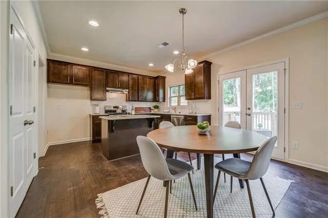 a kitchen with stainless steel appliances granite countertop a stove a sink dishwasher and a refrigerator with wooden floor