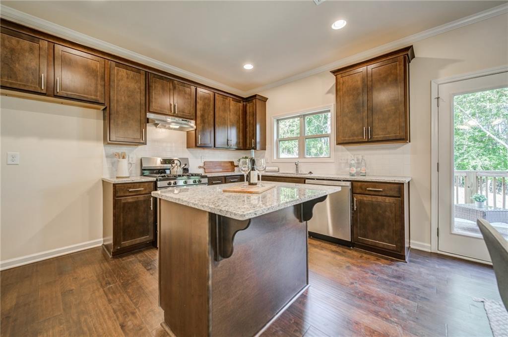3430 South Scales Road Duluth, GA 30097 - Photo 26 of 77 a kitchen with stainless steel appliances granite countertop a stove a sink dishwasher and a refrigerator with wooden floor